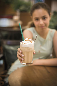 Portrait of woman with drink on table