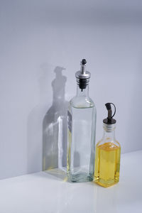 Close-up of glass bottles on table against wall