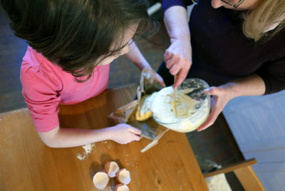 Grandmother and granddaughter preparing food in kitchen