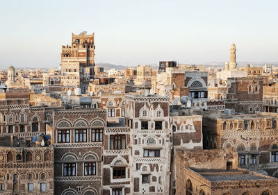 Buildings in city against clear sky