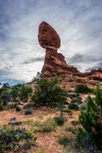 Rock formation on landscape against cloudy sky