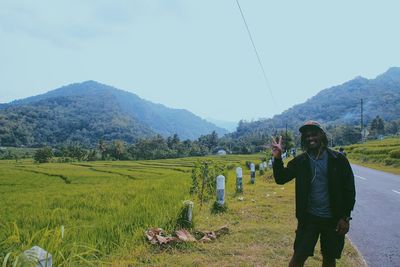 Man standing on field against sky