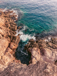 High angle view of rocks on sea shore