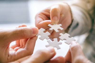 Cropped image of business people holding jigsaw pieces