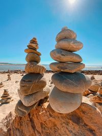 Stack of pebbles on beach against sky