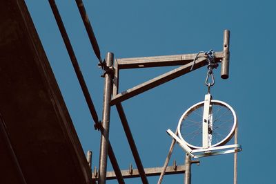 Low angle view of construction site equipment against clear blue sky