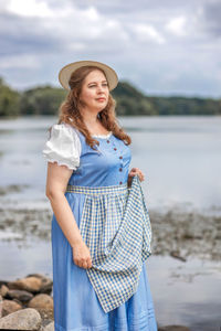 Portrait of young woman standing at beach