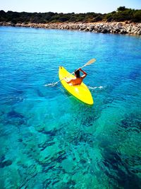 Man on yellow boat in sea