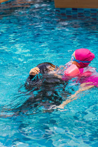 Toddler girl swimming in the pool.cute happy little girl in goggles swimming.