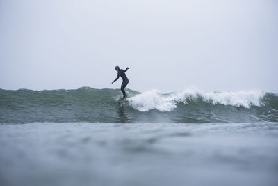 Man standing in sea against sky