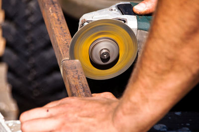 Close-up of hand cutting metal with angle grinder