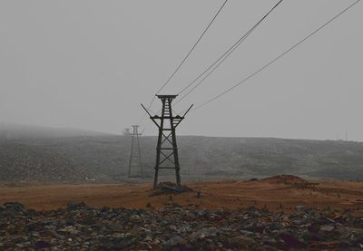 Electricity pylon on landscape against sky