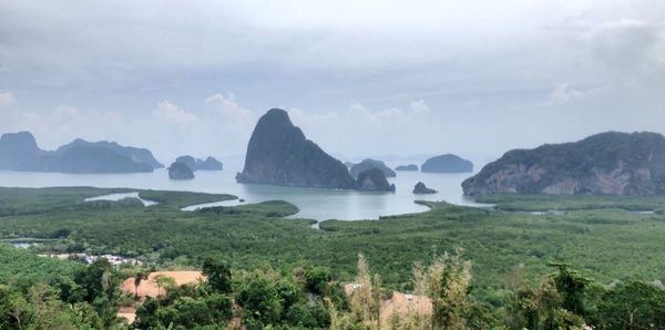 Scenic view of sea and mountains against sky