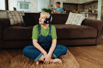 An elderly woman listens to meditation and audio therapy from the living room