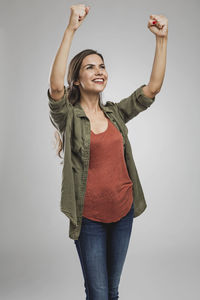 Smiling young woman standing against white background