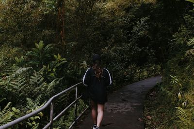 Rear view of woman walking in forest