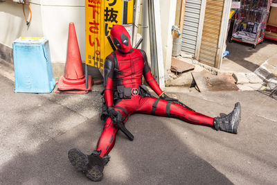 Full length of man sitting on street