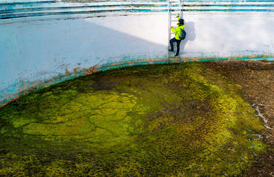 Man climbing stairs of abandoned dirty pool