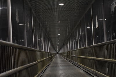 Empty footbridge in illuminated tunnel