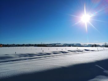 Scenic view of snow covered landscape against blue sky