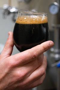 Close-up of hand holding glass of drink