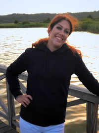 Portrait of smiling young woman standing in lake