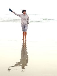 Full length of young man standing on beach