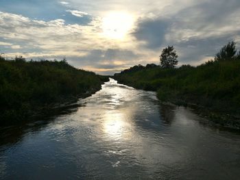 Scenic view of river against cloudy sky