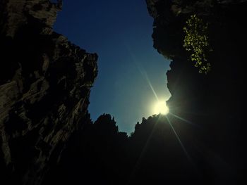 Low angle view of silhouette trees against blue sky