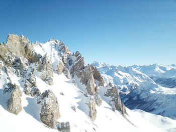 Scenic view of snowcapped mountains against clear blue sky