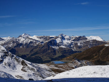 Scenic view of snowcapped mountains against blue sky