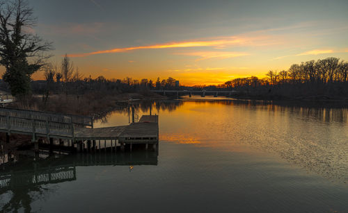 Scenic view of river against sky during sunset