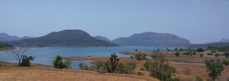 Panoramic view of land and mountains against clear sky