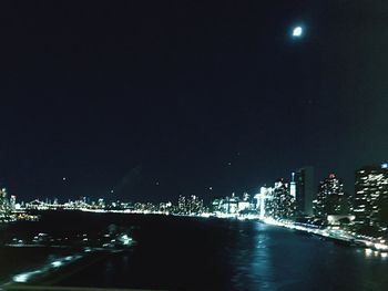 Illuminated city against sky at night