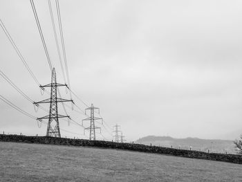 Low angle view of electricity pylon against sky