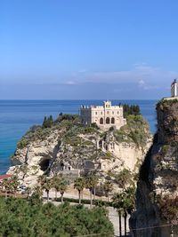 Built structure by sea against sky