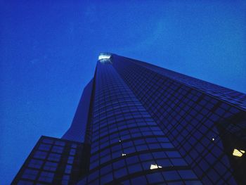 Low angle view of modern building against blue sky