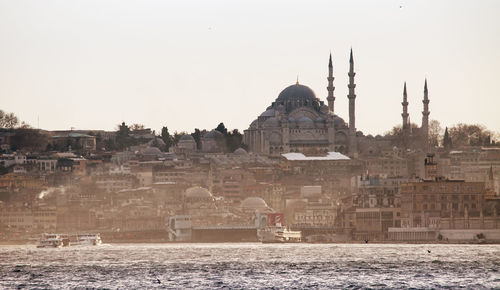 View of mosque and buildings against clear sky