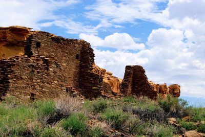 Low angle view of rock formation against cloudy sky