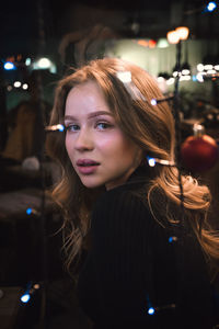 Portrait of young woman in illuminated traditional clothing at night