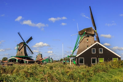 Traditional windmill on field against sky