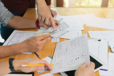 Midsection of business colleagues working on table