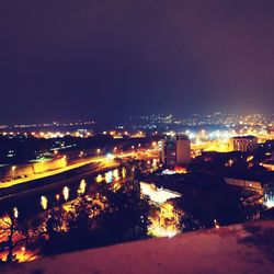 Illuminated cityscape against clear sky at night