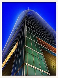 Low angle view of skyscraper against blue sky