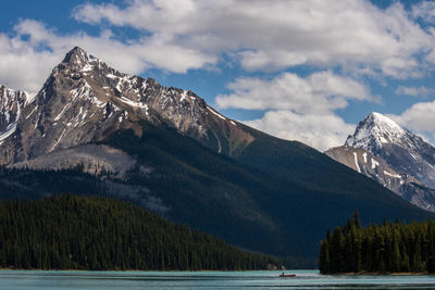 Scenic view of lake by mountains against cloudy sky during winter