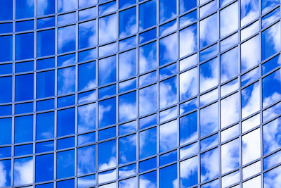 Low angle view of glass building against sky