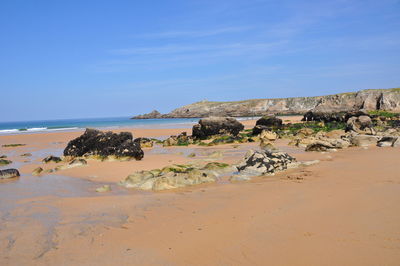 Scenic view of beach against blue sky