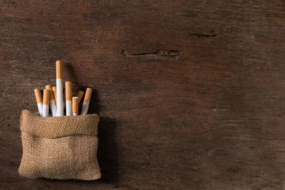 High angle view of cigarettes in jute on wooden table