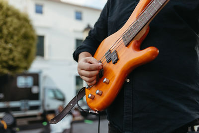 Midsection of man playing guitar