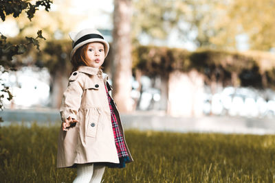 Cute girl looking away while standing at park